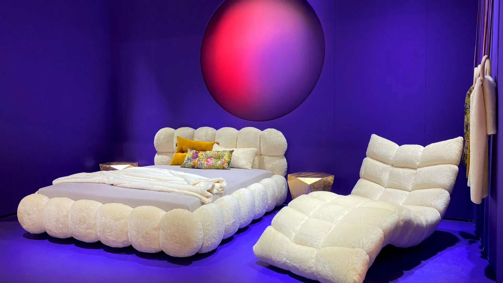 cozy white fluffy bed and chair in a modern purple-themed room with a circular red accent light.